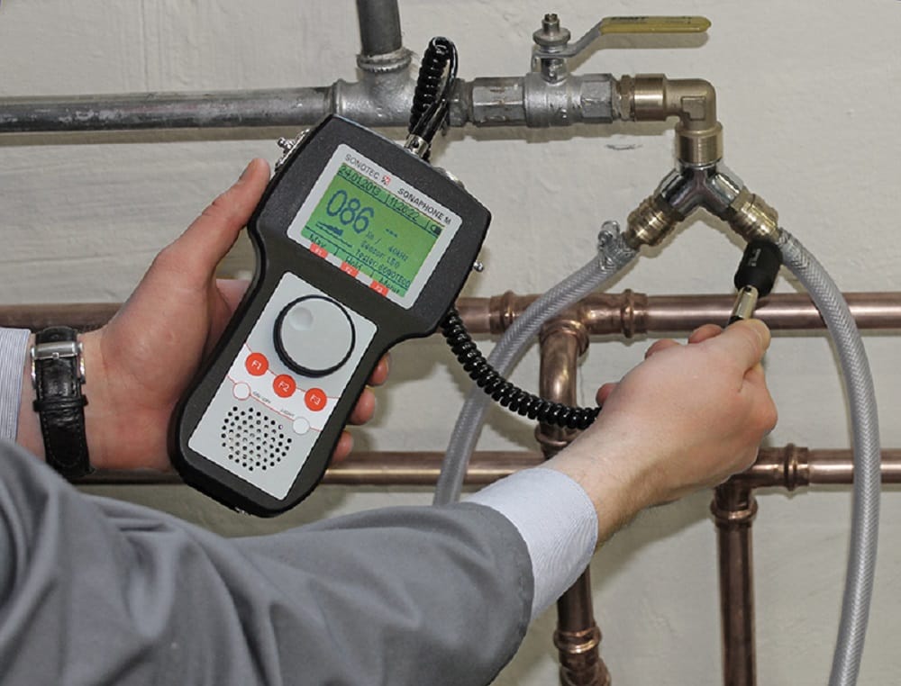 Plumber testing pipes with electronic leak detection equipment in Vancouver