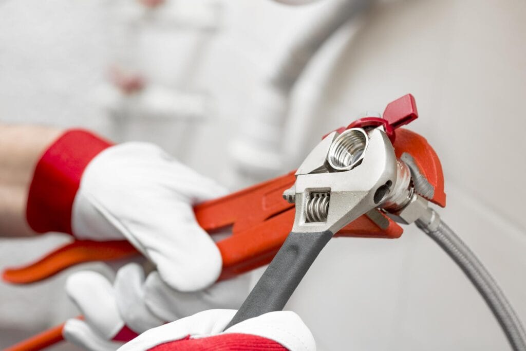 Plumber holding pipe wrenches for an emergency repair in Vancouver