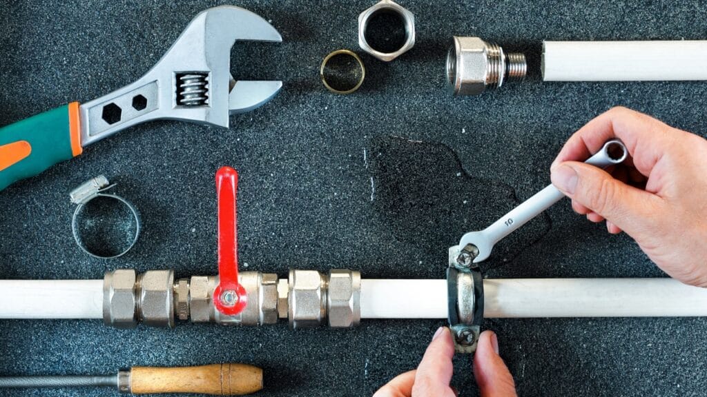 Plumber repairing a pipe valve with an adjustable wrench in Vancouver