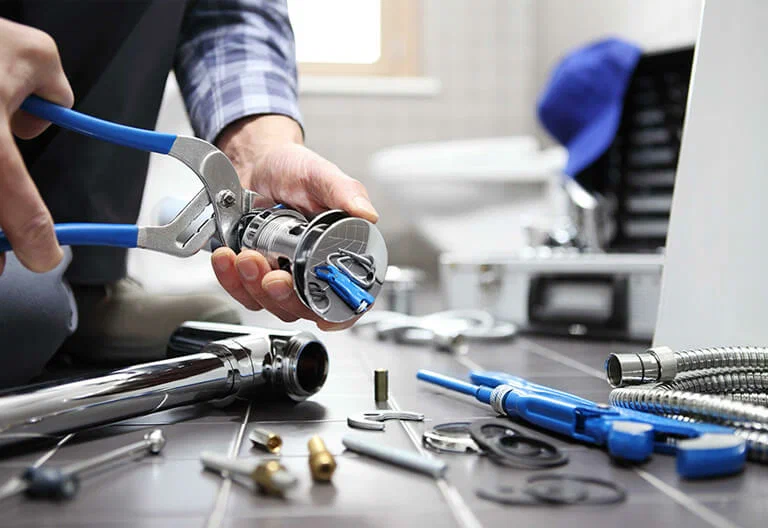 Technician repairing a plumbing fixture with professional tools in Vancouver