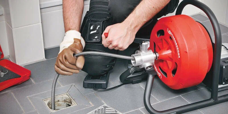 Plumber using a drain-cleaning machine in Vancouver