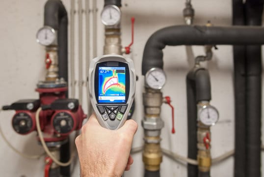 Plumber using a thermal imaging camera to inspect pipes in Vancouver
