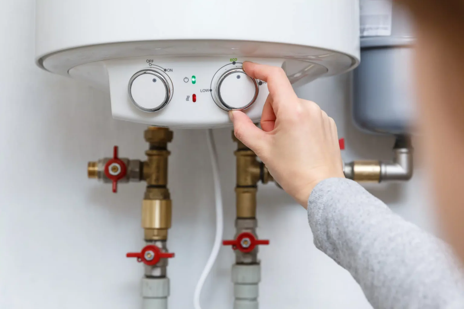 Homeowner adjusting the temperature controls on a water heater in Vancouver